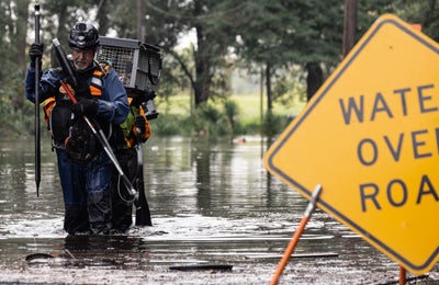 An ASPCA team carrying animals through flooded streets