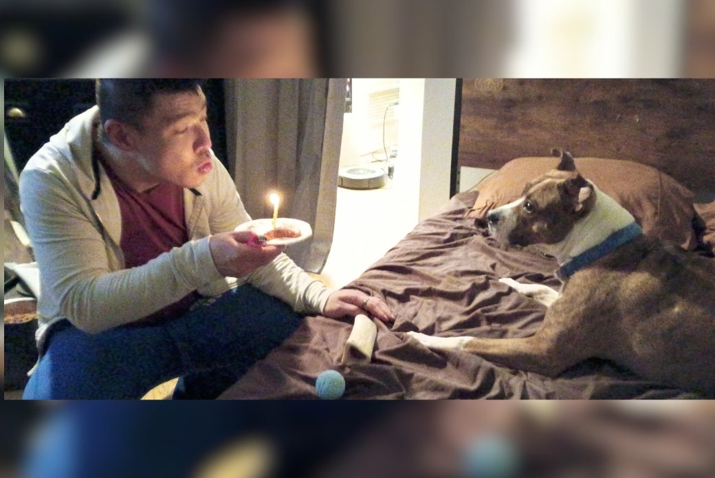 Adopter blowing out birthday candles with his dog