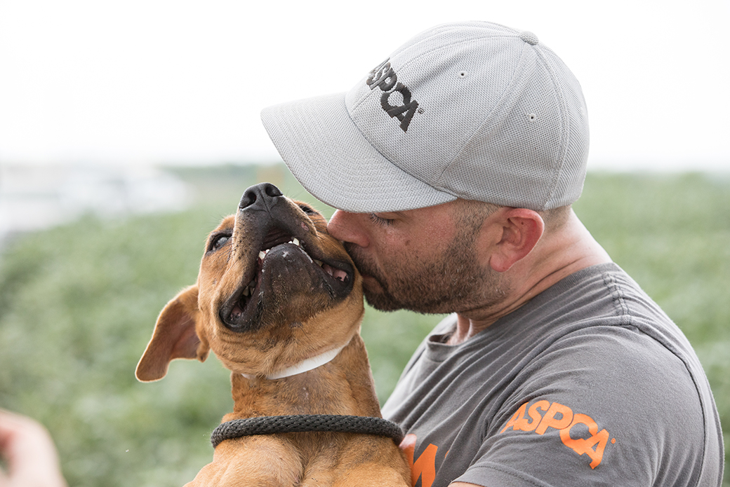 a responder kissing a rescued dog
