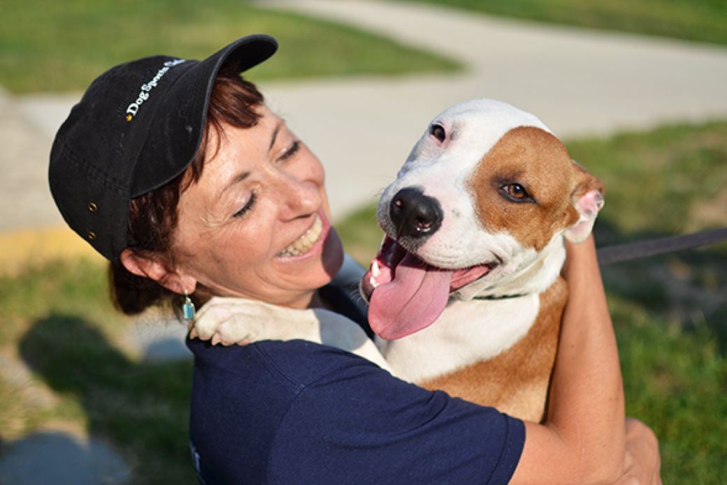 a woman holding a happy pitbull