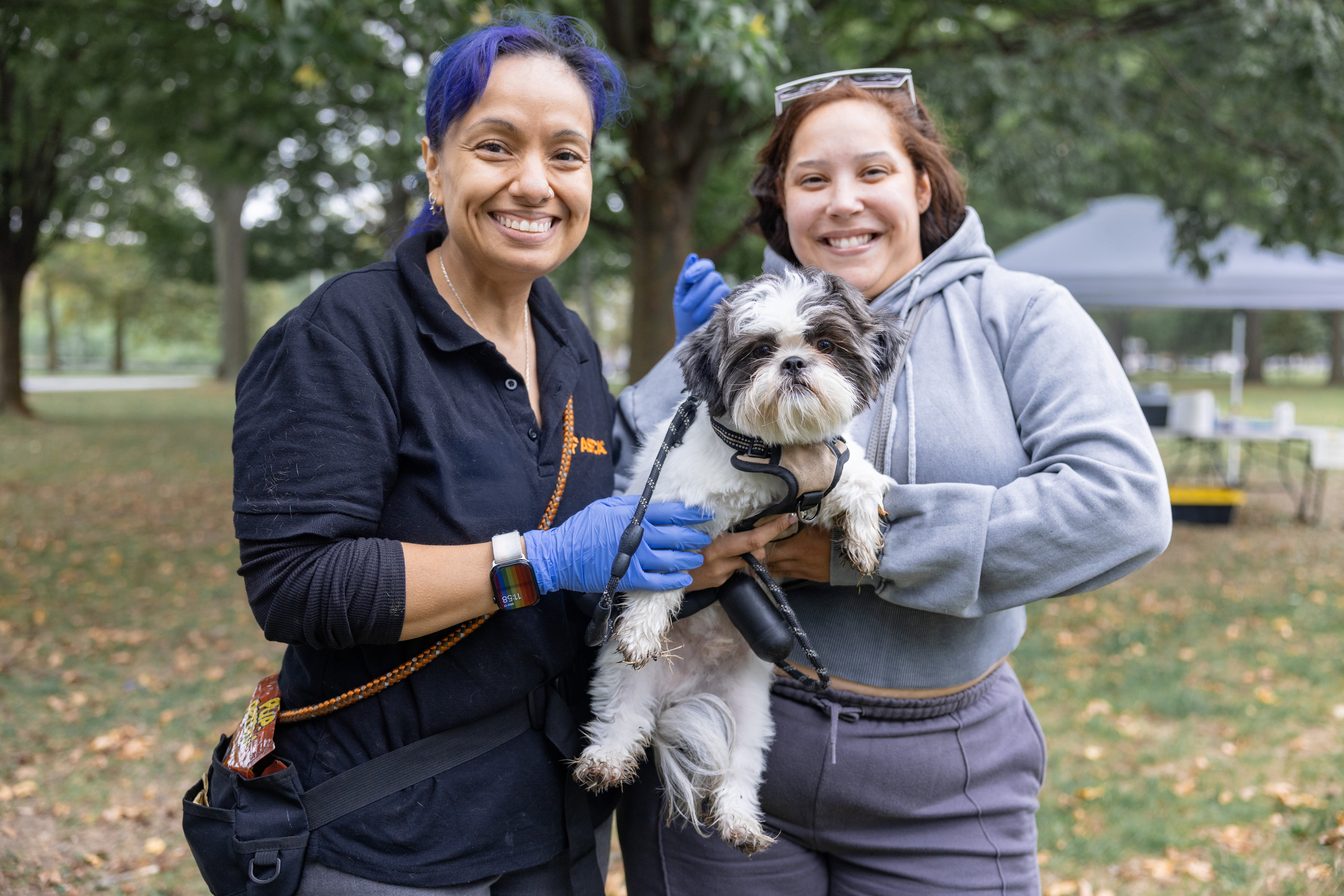 ASPCA community medicine employee standing with community member, holding puppy