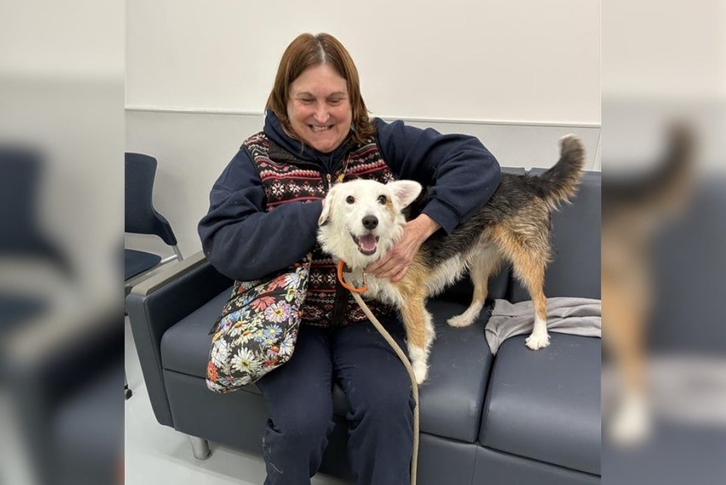 Moon and his adopter, Dede R., sitting on a couch together