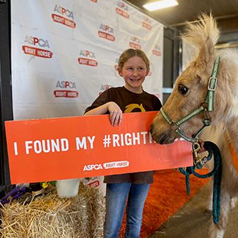 Fiona and Riley with Riley hold a I found my right horse sign