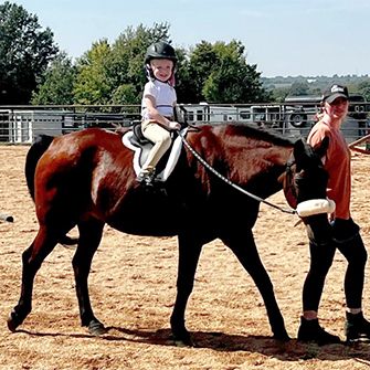 Katie's niece riding Gramps while Katie leads him