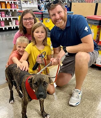 Family surrounding dog and petting him