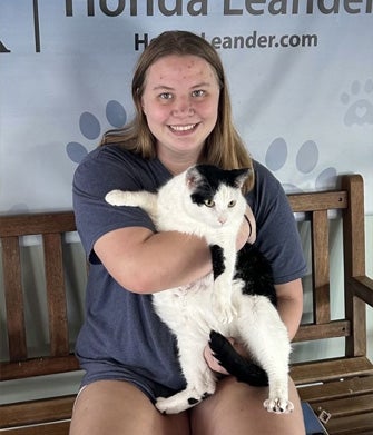Girl holding black and white cat